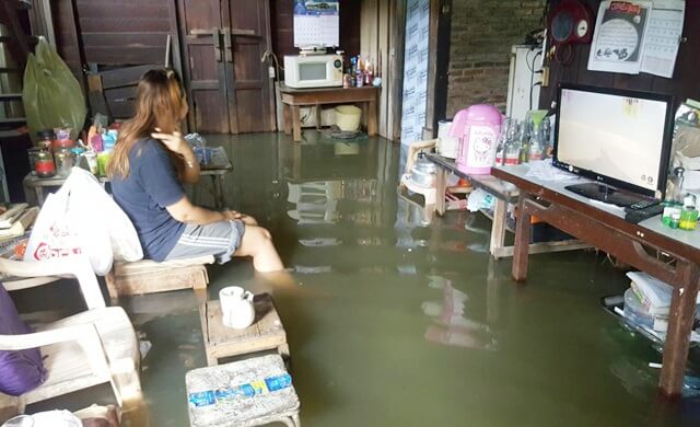 คนนั่งในบ้านน้ำท่วม
