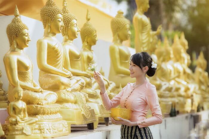 ผู้หญิงสรงน้ำพระพุทธรูปหลายองค์